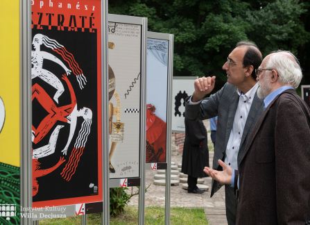 fotografia. art piknik w willi decjusza. plenerowa wystawa plakatów teatralnych. grupa ludzi przed ustawionymi w rzędzie plakatami.